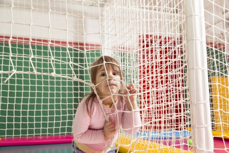 Téléchargez les photos : Enfant joyeux jouant sur un trampoline dans une salle de jeux - en image libre de droit