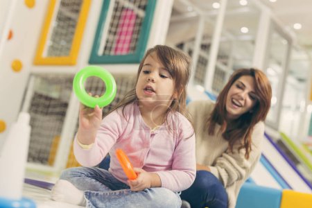 Téléchargez les photos : Belle mère et fille s'amusent à jouer dans une salle de jeux - en image libre de droit