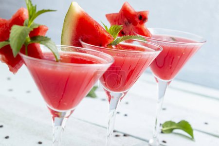 Foto de Cócteles fríos de sandía servidos en vasos de martini como refresco de verano. Enfoque selectivo en la decoración de la sandía en el vidrio medio - Imagen libre de derechos
