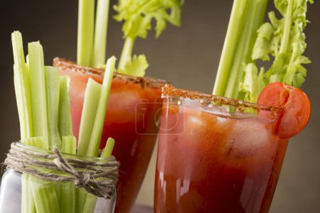 Foto de Cóctel Bloody Mary con vodka, jugo de limón y tomate, salsa de tabasco y cubitos de hielo decorados con hojas de apio. Concéntrate en el vidrio correcto - Imagen libre de derechos
