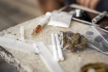 Foto de Vista de alto ángulo de varios tipos de narcóticos: inyección de heroína y polvo, pastillas de éxtasis y cigarrillos de cannabis. Enfoque en la punta de la jeringa - Imagen libre de derechos