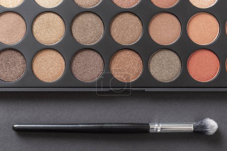 Photo for Top view of an eyeshadow palette and an eyelid make up brush - Royalty Free Image