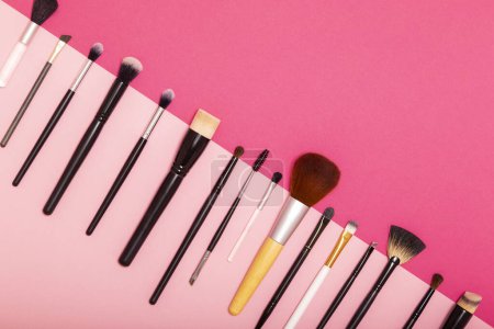 Foto de Conjunto de pinceles planos de maquillaje profesional aislados sobre fondo rosa - Imagen libre de derechos