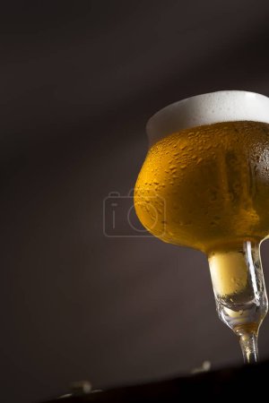 Photo for Detail of a wet glass of cold light beer with foam. Selective focus - Royalty Free Image