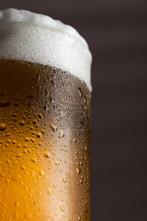 Téléchargez les photos : Détail d'un verre mouillé de bière froide légère avec mousse. Concentration sélective - en image libre de droit