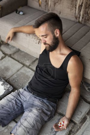Foto de Hombre acostado en el suelo después de una sobredosis de pastillas y cometiendo un ataque suicida - Imagen libre de derechos