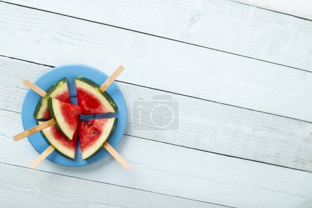 Photo for Table top shot of watermelon popsicles on a plate on rustic light blue wooden table - Royalty Free Image