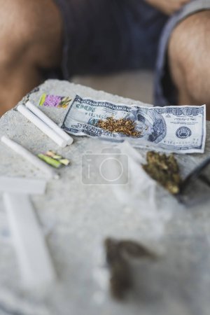 Téléchargez les photos : Vue grand angle des bourgeons de cannabis et des joints roulés sur une table en béton - en image libre de droit