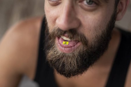 Foto de Joven tomando LSD; tarjeta LSD en la lengua de un hombre. Concéntrate en el sello LSD - Imagen libre de derechos