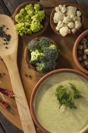 Téléchargez les photos : Plan de table de soupe fraîche à la crème de brocoli décorée de feuilles d'aneth. Focus sur les feuilles d'aneth - en image libre de droit