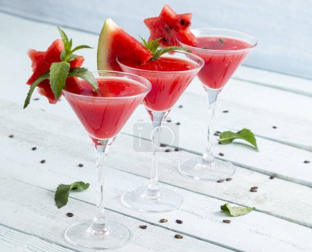 Foto de Cócteles fríos de sandía servidos en vasos de martini como refresco de verano. Concéntrate en el vidrio en el medio - Imagen libre de derechos