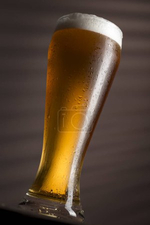 Téléchargez les photos : Verre de bière froide et pâle posé sur une table rustique en bois. Concentration sélective - en image libre de droit