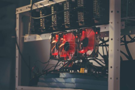 Photo for Mining rig for cryptocurrency digging set up and operational. Selective focus on the cooler and a GPU - Royalty Free Image