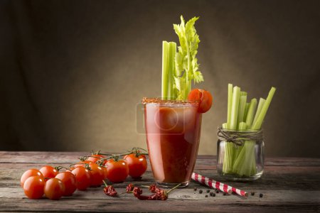 Foto de Cóctel Bloody Mary con vodka, jugo de limón y tomate, salsa de tabasco y cubitos de hielo decorados con hojas de apio - Imagen libre de derechos