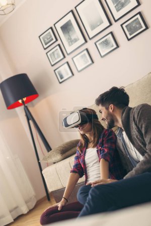 Téléchargez les photos : Couple en amour avoir du plaisir à regarder une réalité virtuelle vidéo 3D. Focus sur la femme - en image libre de droit