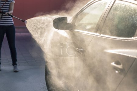 Foto de Detalle de lavar un coche con agua caliente a alta presión y detergente en un lavado de autos. - Imagen libre de derechos