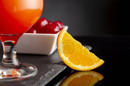 Photo for Detail of cold tequila sunrise cocktails with tequila, pomegranate juice and orange juice decorated with slices of orange and maraschino cherries - Royalty Free Image