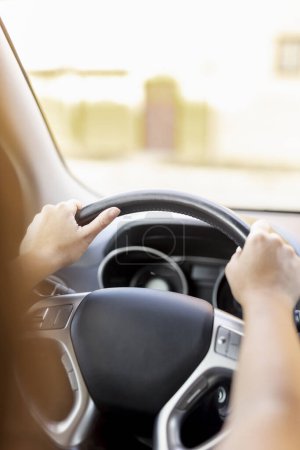 Foto de Detalle de las manos femeninas sosteniendo un volante mientras conduce un coche - Imagen libre de derechos