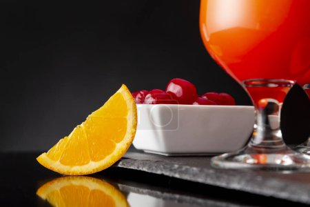 Photo for Detail of cold tequila sunrise cocktails with tequila, pomegranate juice and orange juice decorated with slices of orange and maraschino cherries. Focus on the orange slice - Royalty Free Image