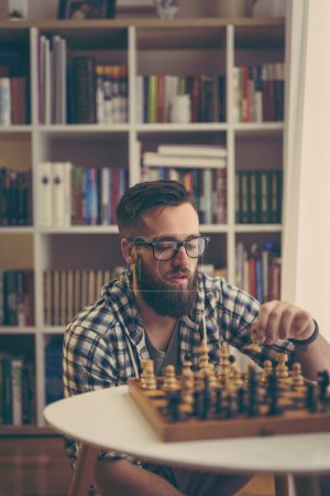 Photo for Man playing chess at home, enjoying his leisure time - Royalty Free Image