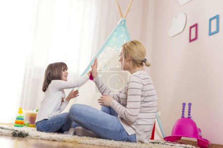Foto de Madre e hija jugando en una sala de juegos - Imagen libre de derechos