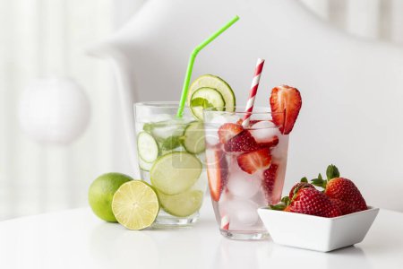 Téléchargez les photos : Verres d'eau infusée de fraises fraîches et de feuilles de citron vert, de concombre et de menthe. - en image libre de droit