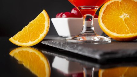 Photo for Detail of cold tequila sunrise cocktails with tequila, pomegranate juice and orange juice decorated with slices of orange and maraschino cherries - Royalty Free Image