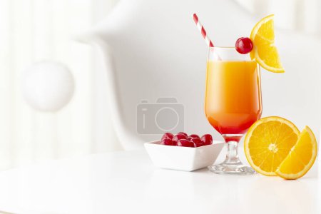 Photo for Cold tequila sunrise cocktail with tequila, pomegranate juice and orange juice decorated with slices of orange and maraschino cherries - Royalty Free Image