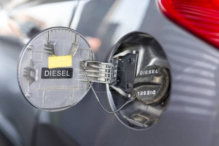 Foto de Cierre de la puerta del depósito de combustible del automóvil; repostaje de automóviles en una gasolinera; llenado de tanques de automóviles en una gasolinera - Imagen libre de derechos