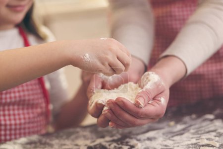 Téléchargez les photos : Détail des biscuits de cuisson mère et fille, jouer avec la farine sur le comptoir de la cuisine. Focus sélectif sur les doigts - en image libre de droit