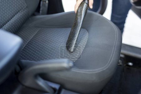 Téléchargez les photos : Détail de la main féminine tenant un aspirateur et aspirant sièges d'auto et intérieur - en image libre de droit