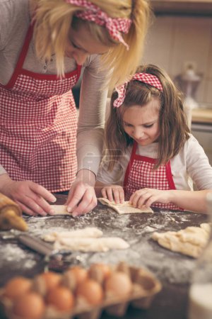 Foto de Madre e hija en la cocina haciendo rollos - Imagen libre de derechos