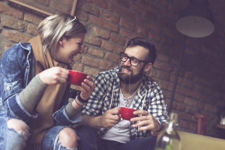 Téléchargez les photos : Jeune couple amoureux assis dans un café, boire un café le matin et avoir une conversation agréable - en image libre de droit