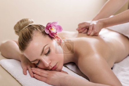 Foto de Mujer tumbada en un salón de belleza, disfrutando de un relajante masaje de espalda - Imagen libre de derechos