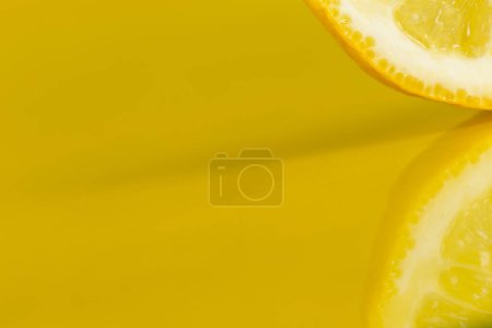 Téléchargez les photos : Détail d'une tranche de citron isolée sur fond jaune, plan studio - en image libre de droit
