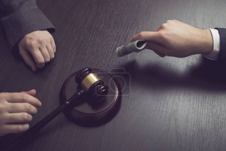 Photo for Detail of a criminal offering bribe money to a corrupted judge. Selective focus - Royalty Free Image