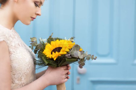 Téléchargez les photos : Portrait d'une belle mariée dans une robe de mariée, tenant un bouquet de mariage de tournesol - en image libre de droit