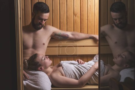Photo for Young couple enjoying the sauna session together and relaxing - Royalty Free Image