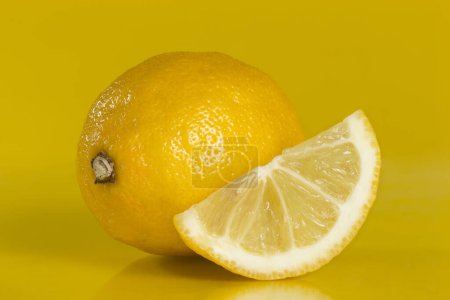 Téléchargez les photos : Plan studio d'un tout et d'une tranche de citron isolé sur fond jaune. Focus image empilée - en image libre de droit