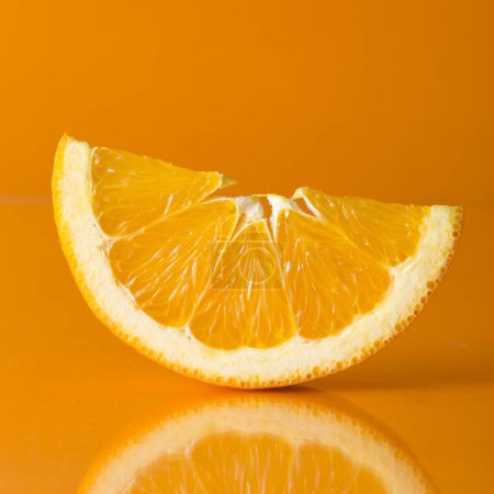 Photo for Studio shot of slice of orange fruit isolated on orange background. - Royalty Free Image