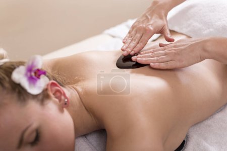 Photo for Woman lying in a beauty parlour, enjoying relaxing back massage with chocolate. Selective focus - Royalty Free Image