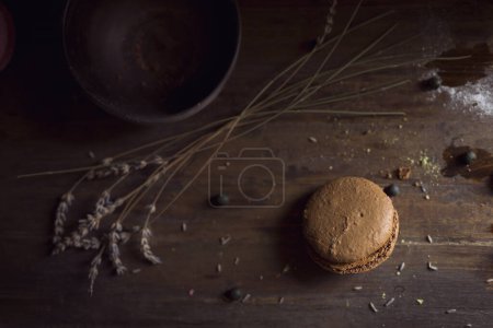 Foto de Vista superior de una galleta macaron, frutas de cereza y flores de lavanda sobre la mesa. Enfoque selectivo en la cookie. - Imagen libre de derechos