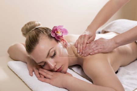 Photo for Woman lying in a beauty parlour, enjoying relaxing back massage - Royalty Free Image