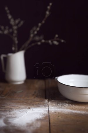 Photo for Old kitchen dishes and a messy workspace covered in flour after kneading a dough. Selective focus - Royalty Free Image