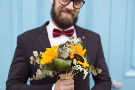 Téléchargez les photos : Beau hipster tenant un bouquet de mariage de tournesol. Focus sélectif sur la main et les fleurs - en image libre de droit