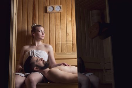 Téléchargez les photos : Jeune couple profitant de la séance de sauna ensemble et relaxant. Concentre-toi sur la fille - en image libre de droit