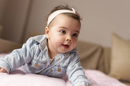 Photo for Beautiful baby girl crawling and rolling over in bed - Royalty Free Image