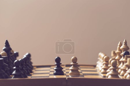 Foto de Tablero y piezas de ajedrez de madera, peones blancos y negros colocados uno contra el otro. Enfoque selectivo - Imagen libre de derechos