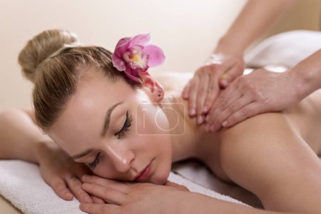 Photo for Woman lying in a beauty parlour, enjoying relaxing back massage - Royalty Free Image