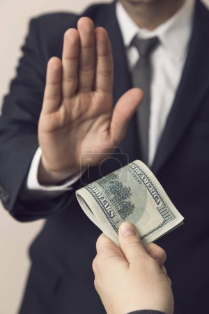 Photo for Detail of an honest businessman refusing a bribe money. Focus on the thumb of the bribe giver - Royalty Free Image